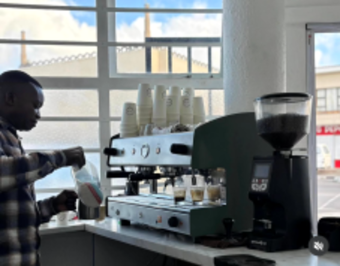 The barista pulling shots on the espresso machine at Cave Cafe
